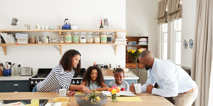 Young black family busy together in their kitchen