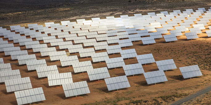 Rows of solar panels in arid landscape,